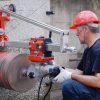 Construction worker drill a wall with CARDI 501 core drill on stand.