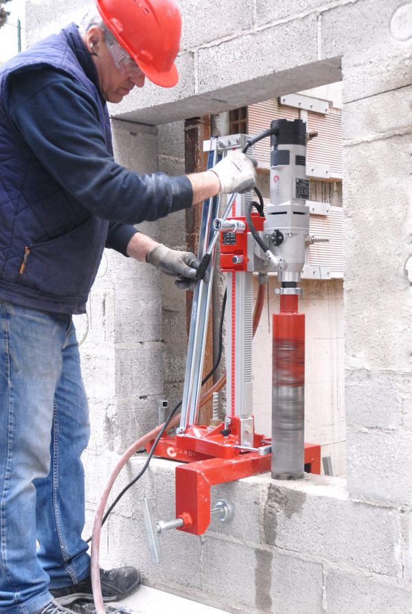 CARDI core drill drill a wall using wall clamp fixing accessory.