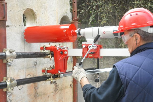 CARDI core drill on support fixed on scaffolding while drilling a wall.